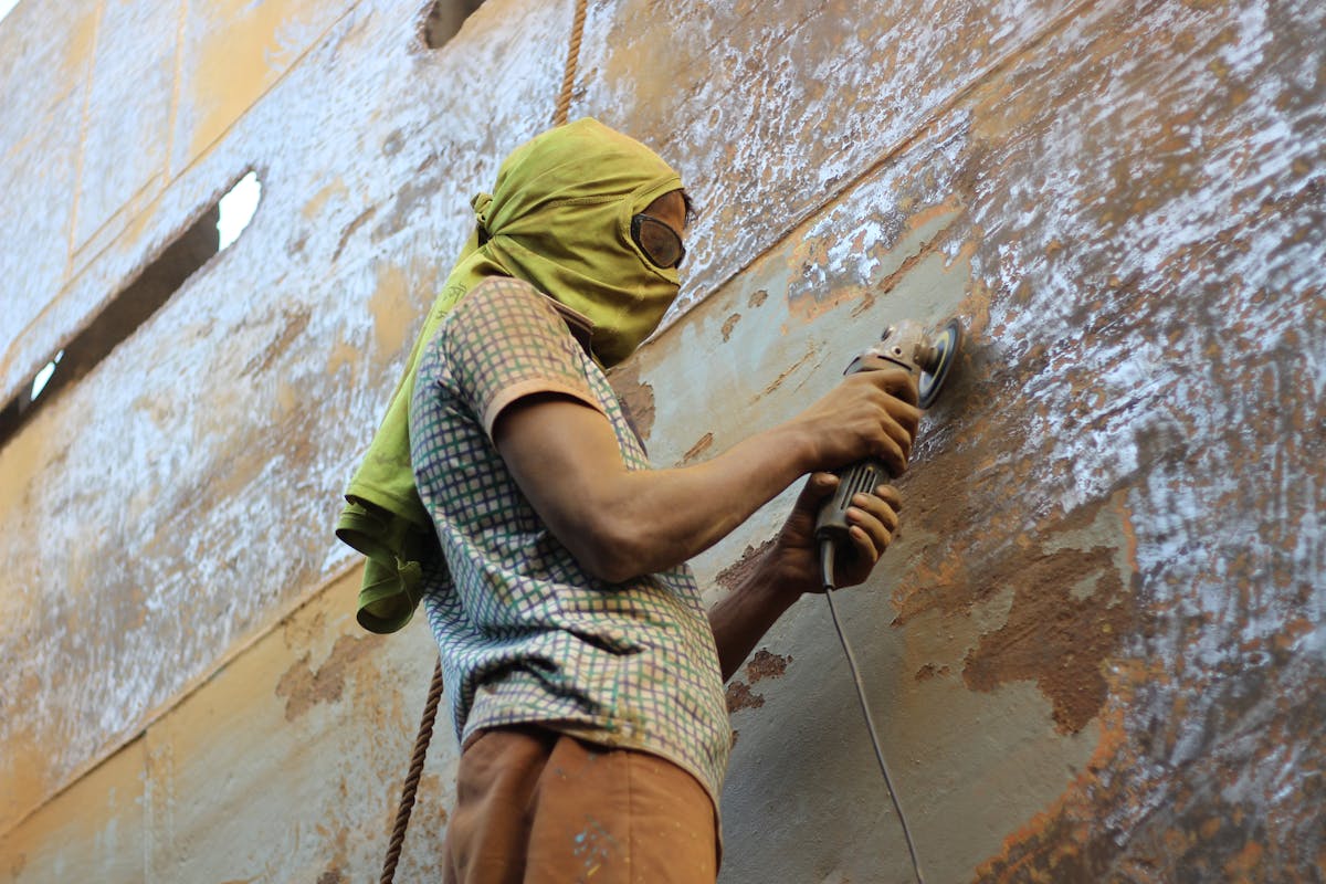 Worker using angle grinder for dustless concrete floor grinding in Washington UT
